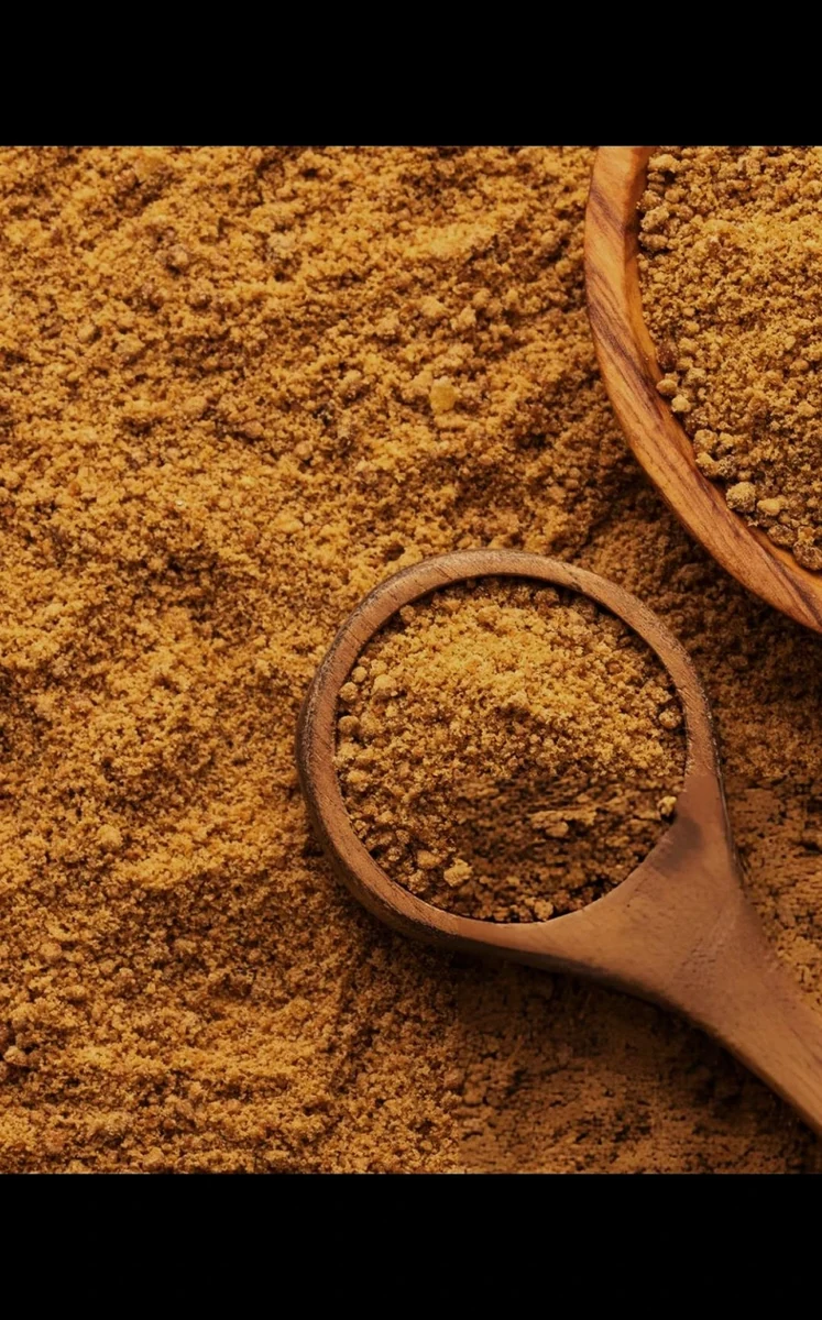 Natural jaggery powder in wooden scoop